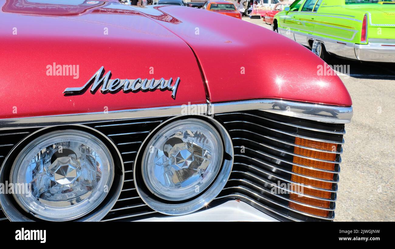 Logo sur le capot d'une voiture classique 1976 Mercury Cougar XR7 de couleur bordeaux avec partie de la calandre et des phares; coupé américain deux portes. Banque D'Images