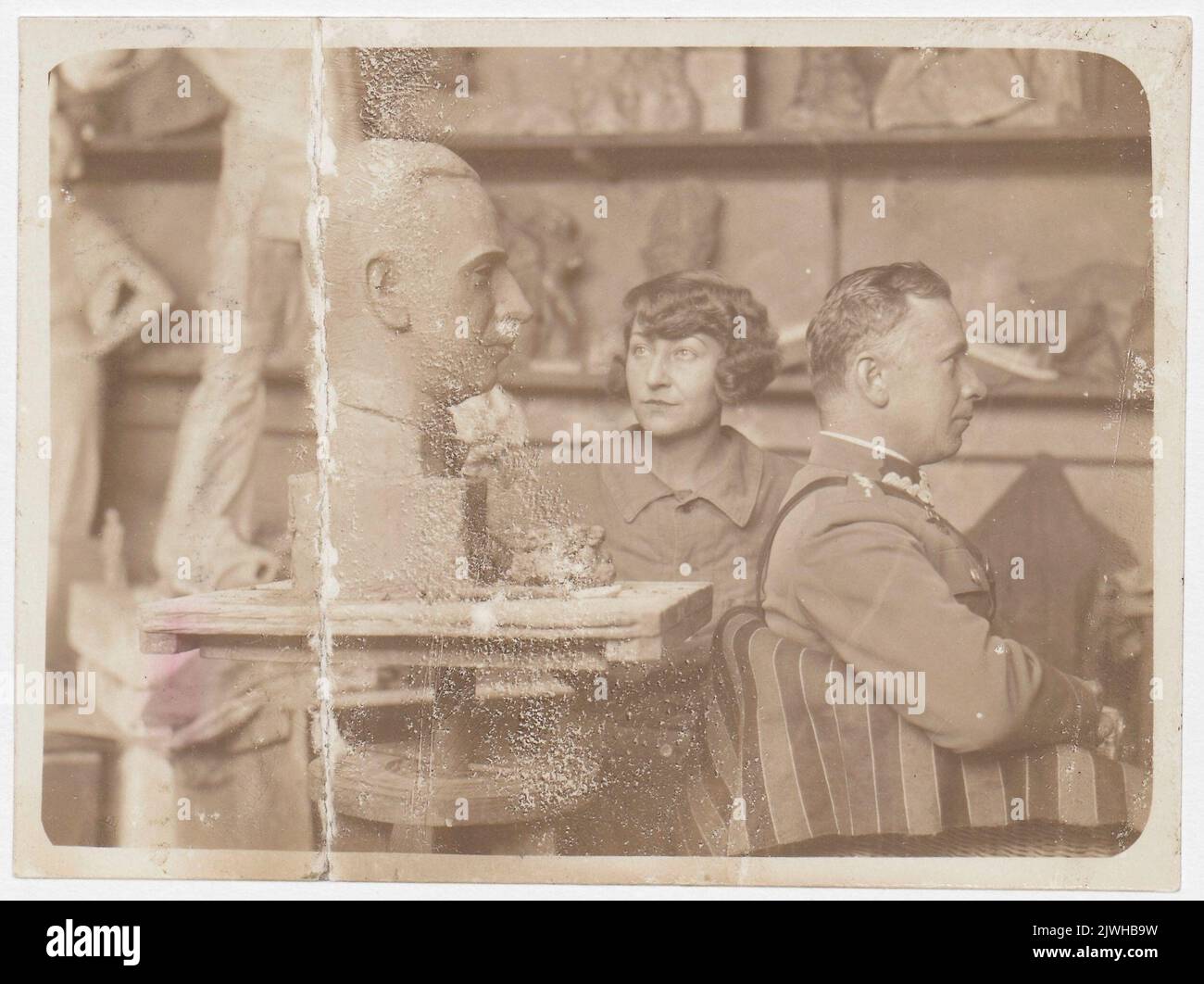 Olga Niewska à son atelier à la rue Zakroczymska à Varsovie, avec une de ses sculptures de portrait (tête mâle), et avec le modèle de pose (homme en uniforme). Inconnu, photographe Banque D'Images