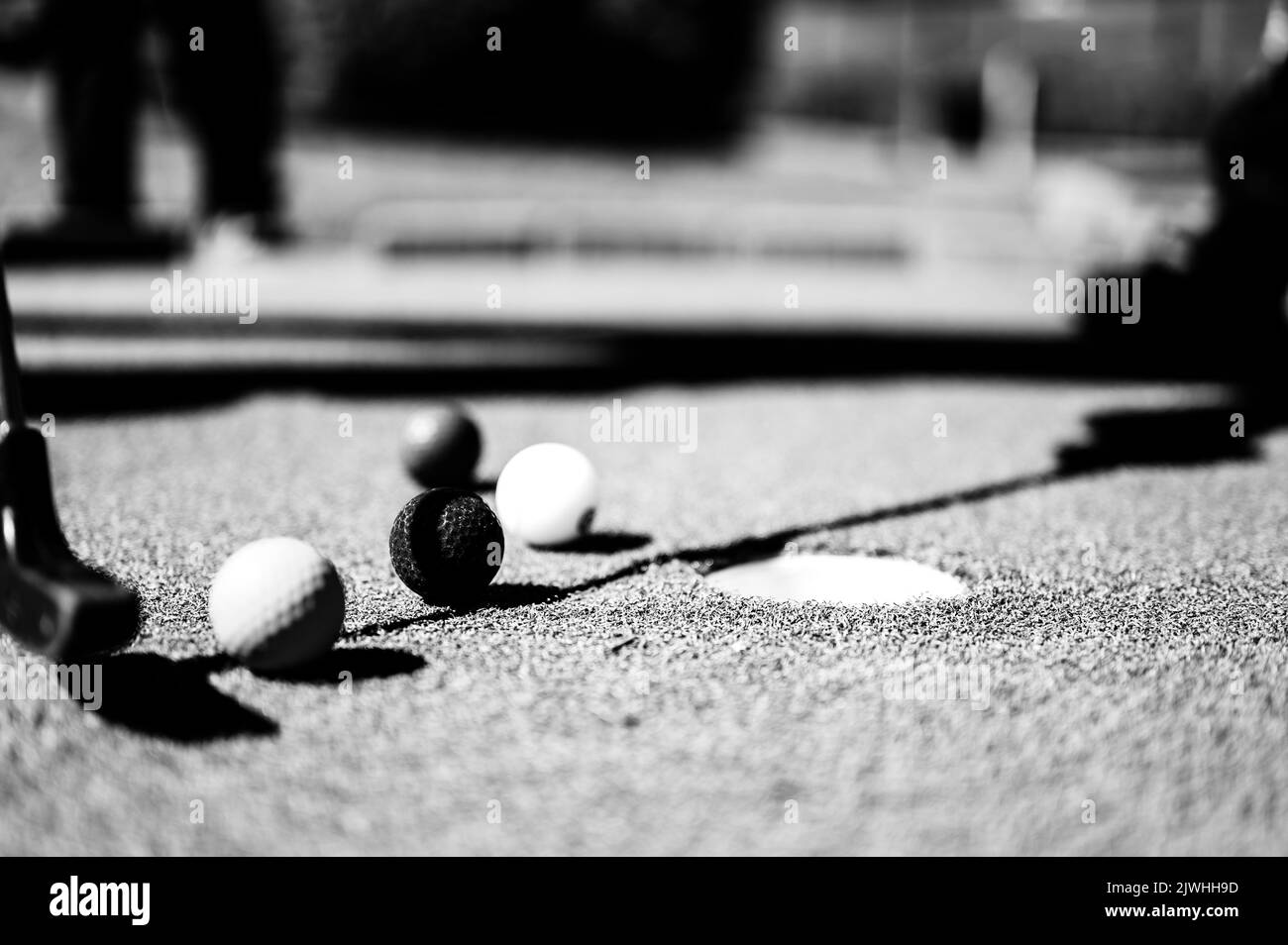 Mini-jeu de golf avec plusieurs balles de couleur dans la manière d'un putter aligné. Banque D'Images