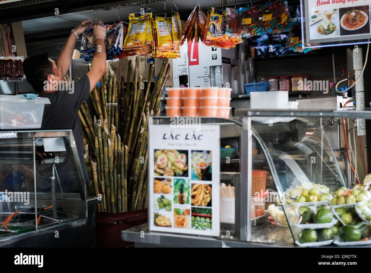 Homme vendant des fruits frais et du jus de canne à sucre dans un magasin de Cabramatta — Sydney, Australie Banque D'Images