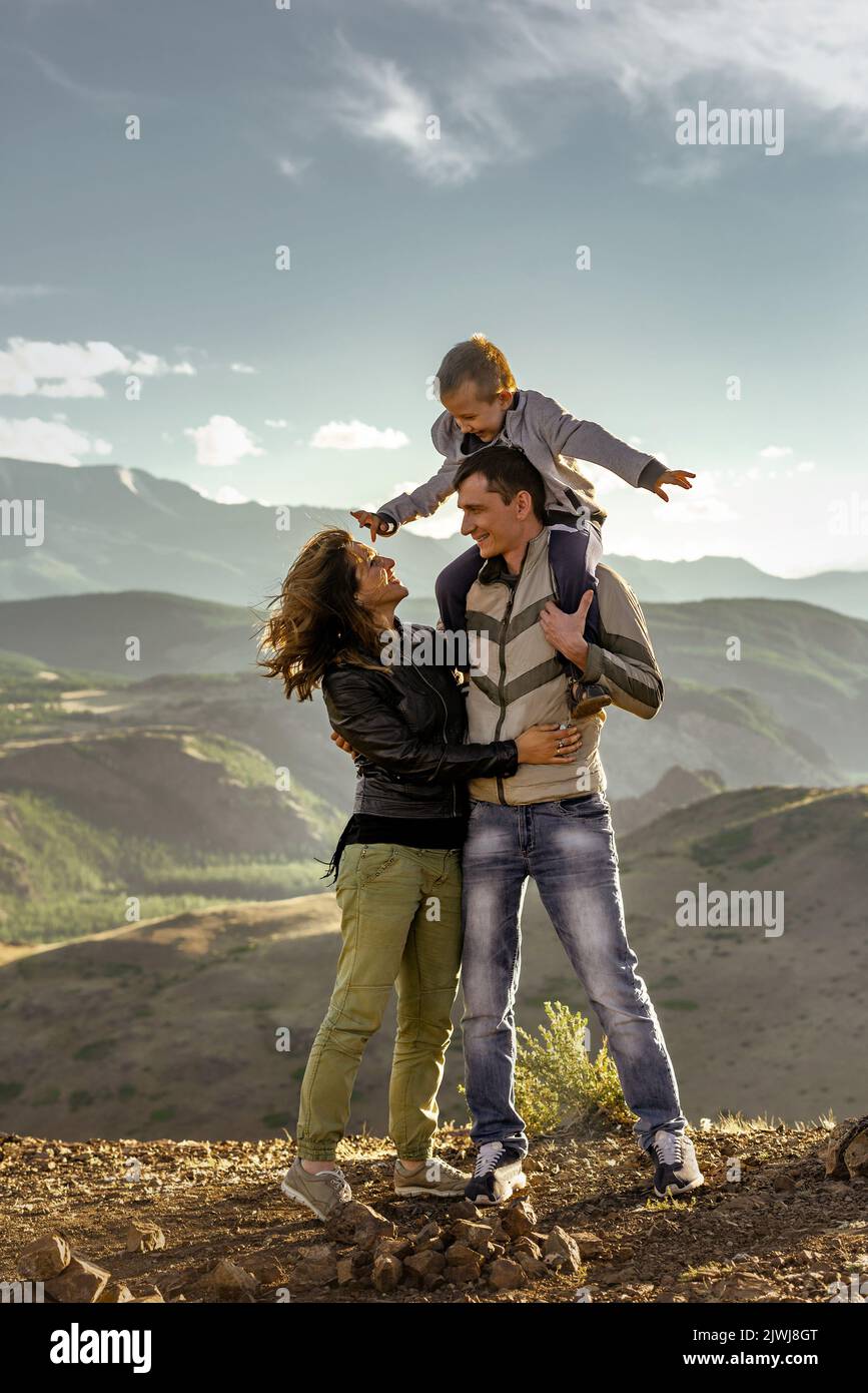 Une famille heureuse avec son père, sa mère et son fils marche ensemble dans les montagnes Banque D'Images