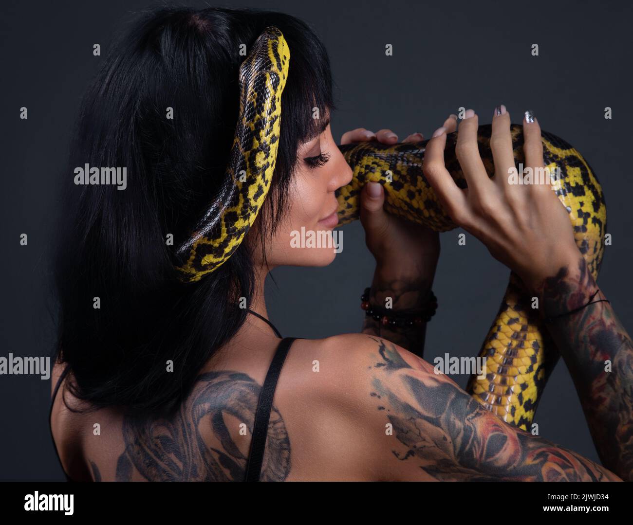 Image de la femme avec anaconda jaune sur les épaules et la tête Banque D'Images
