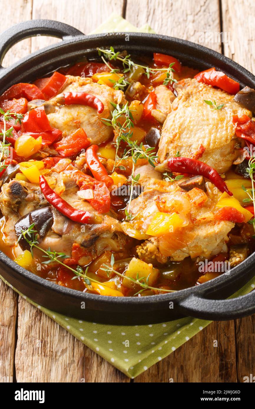 Poulet Kedjenou Côte d'Ivoire ragoût de légumes dans le jus propre, dans l'assiette sur la table. Verticale Banque D'Images