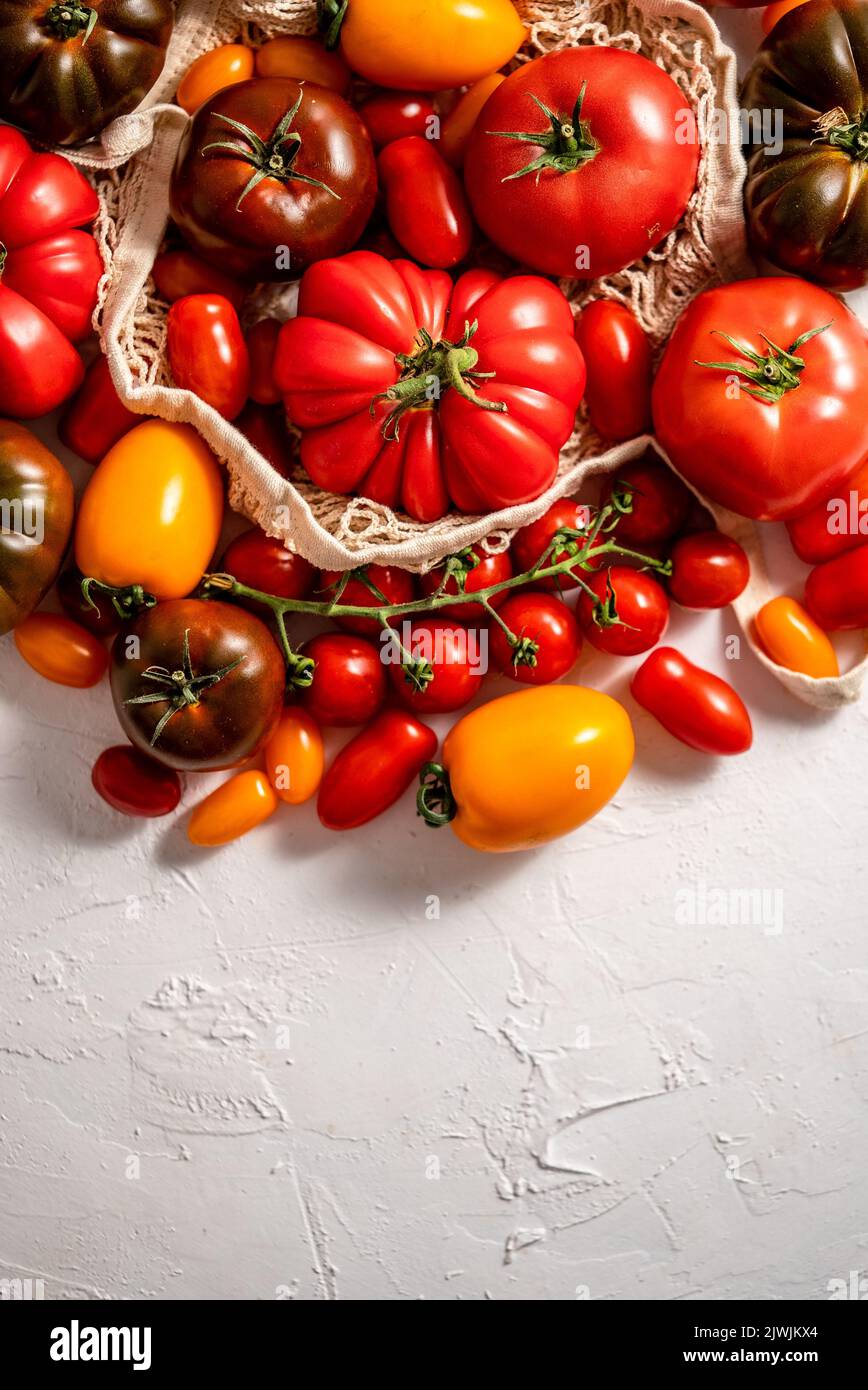 Tomates sur la table. Tomates de différentes variétés. Composition circulaire avec espace de copie Banque D'Images