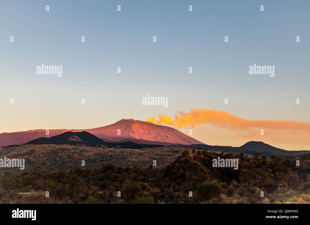 Un long jet de pistes de fumée depuis le sommet de l'Etna, éclairé par le soleil couchant, vu du côté ouest (Sicile, Italie) Banque D'Images