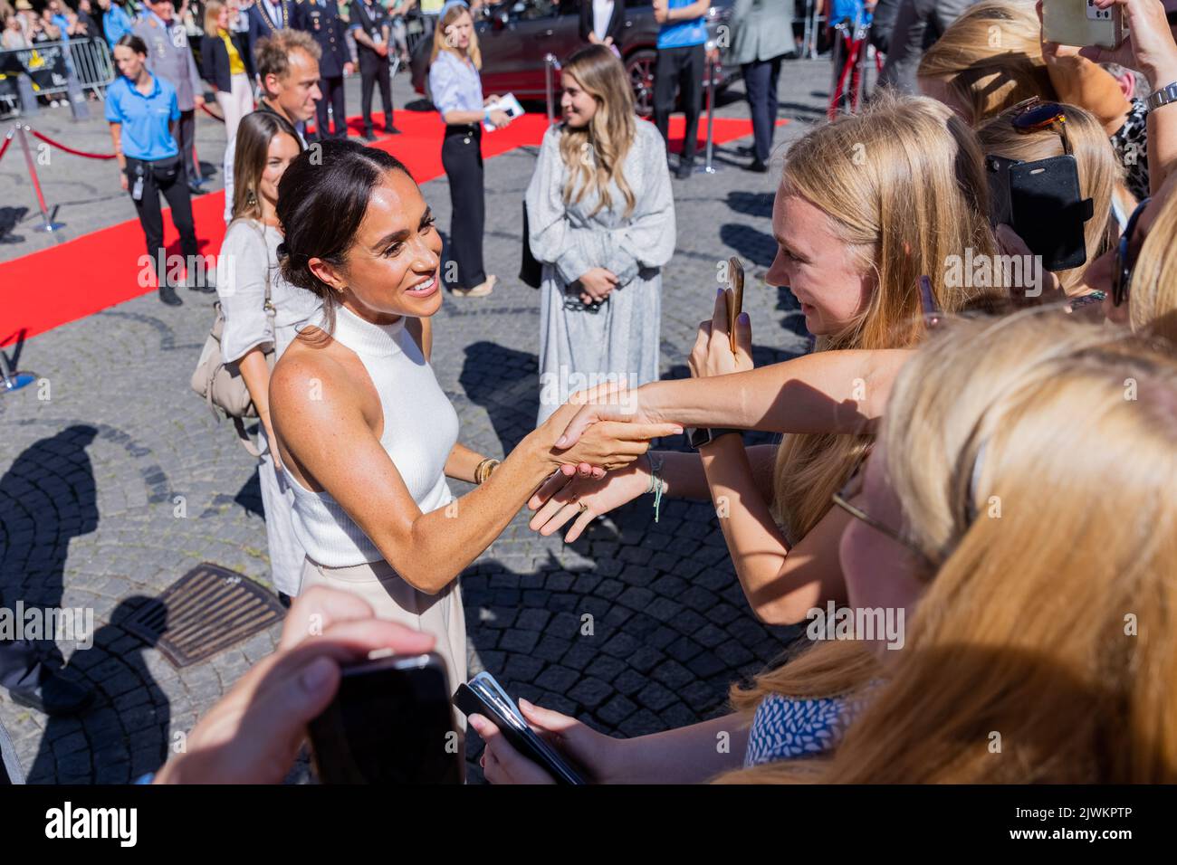 Düsseldorf, Allemagne. 06th septembre 2022. Le prince Harry de Grande-Bretagne (non représenté), duc de Sussex, et sa femme Meghan, duchesse de Sussex (l), sortent de l'hôtel de ville et parlent à des gens qui ont attendu à l'extérieur. Au cours du processus, Meghan serre la main avec deux jeunes femmes. Le prince et sa femme viennent à Düsseldorf pour promouvoir les 'Invictus Games' 2023, que le prince Harry a aidé à lancer. Il s'agit de compétitions paralympiques pour les soldats qui ont été blessés en guerre. Credit: Rolf Vennenbernd/dpa/Alay Live News Banque D'Images