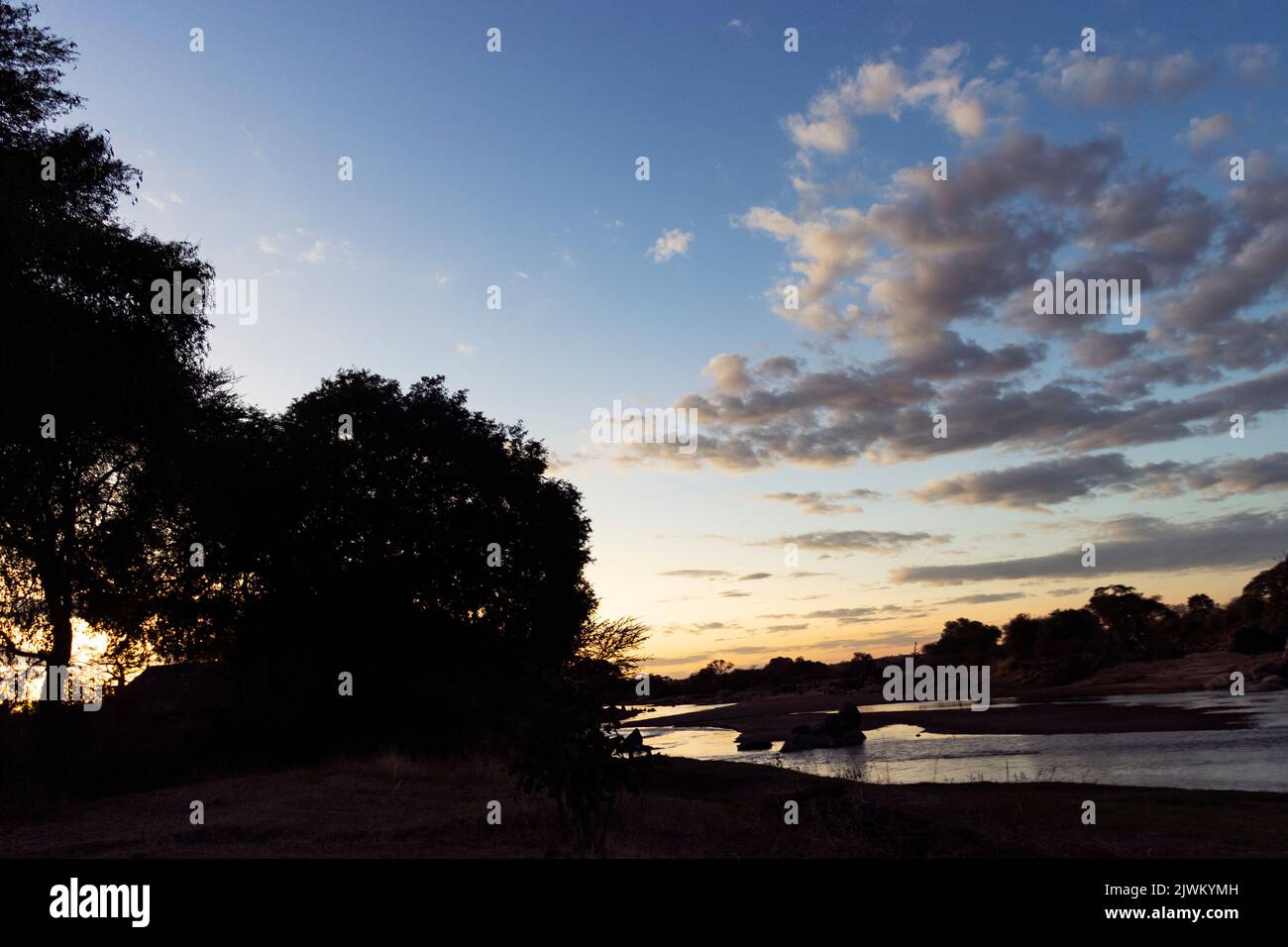 Le crépuscule s'installe au-dessus de la Grande rivière Ruaha sur le site du camp de la rivière Ruaha. Situé sur les rives de la rivière, au cœur de la nature sauvage, il offre des vues Banque D'Images