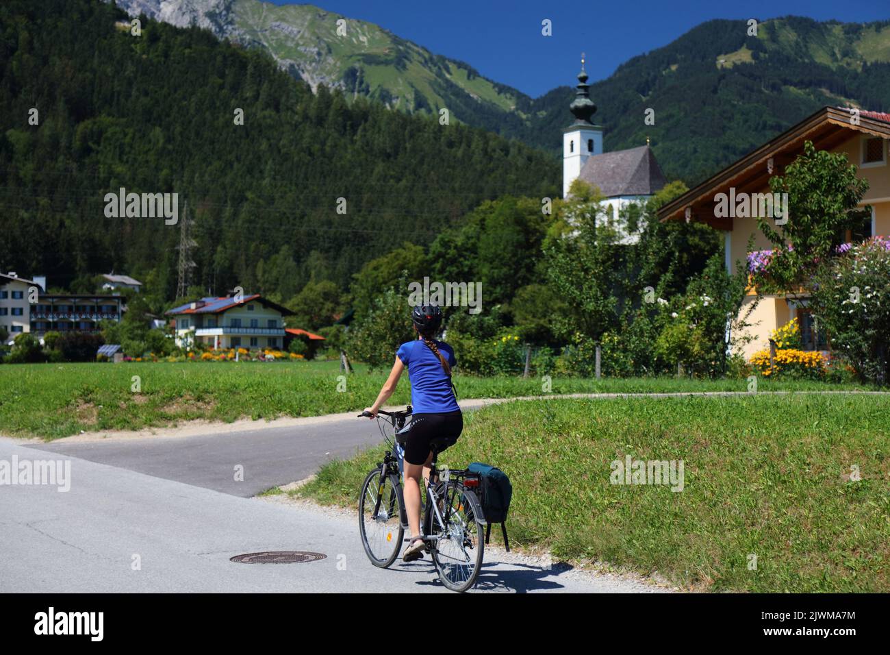 SALZBURG, AUTRICHE - 4 AOÛT 2022 : une cycliste féminine admire des villages et des montagnes près de Salzbourg tout en pédalant sur la piste cyclable longue distance Tauernradweg Banque D'Images