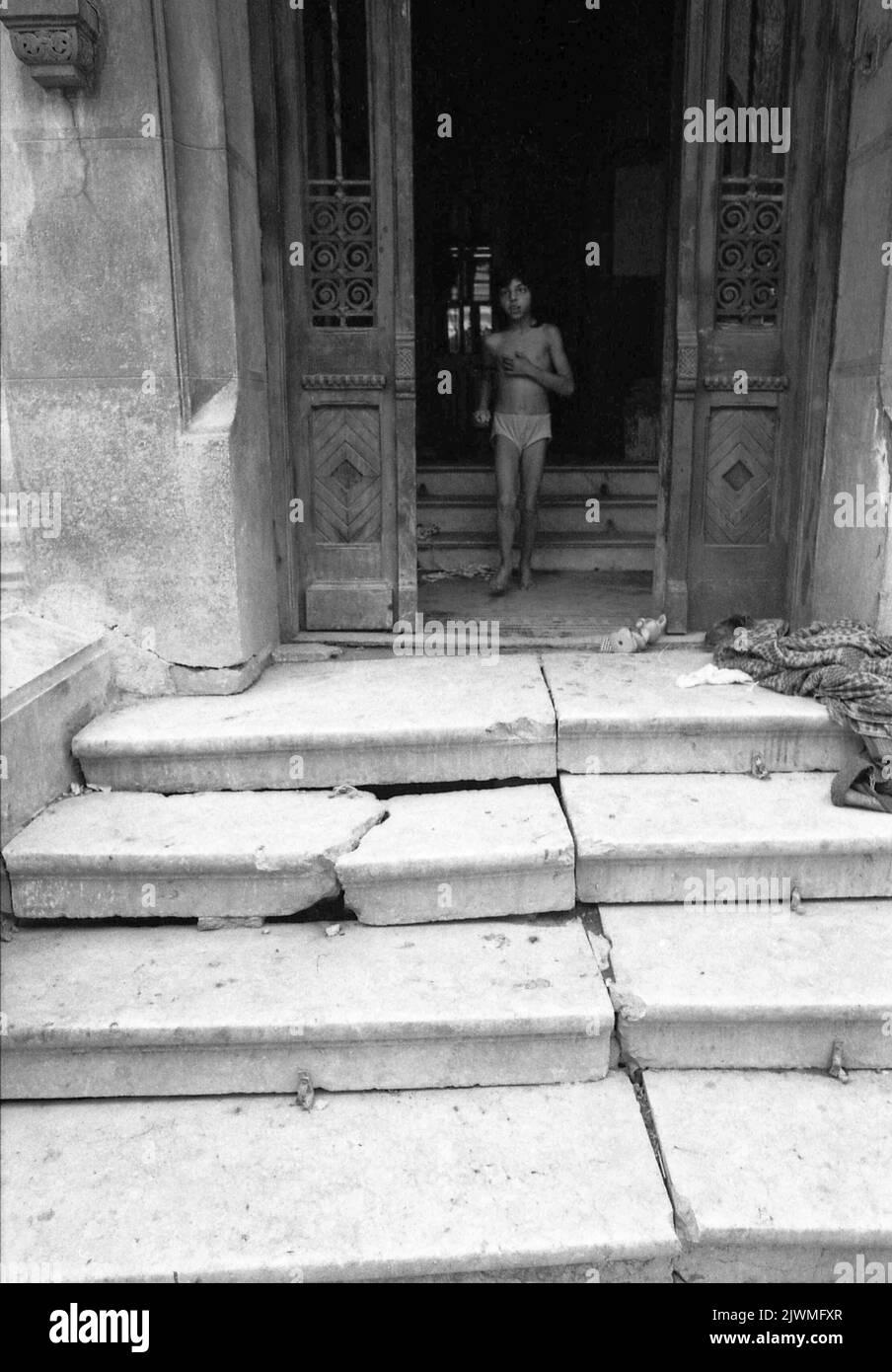 Bucarest, Roumanie, avril 1990, quelques mois après la chute du communisme. Alors que Ceausescu se concentrait sur la construction de ses projets mégalomaniques, comme le Centre civique, les quartiers historiques de la capitale se détérioraient lentement. Quelques maisons historiques dans les environs de la victoire de socialisme Blvd. Ont été évacuées pour la démolition, et à peine échappé grâce à la révolution anti-communiste. Entre-temps, certains d'entre eux étaient illégalement occupés par des familles tziganes sans abri (rroma). Banque D'Images