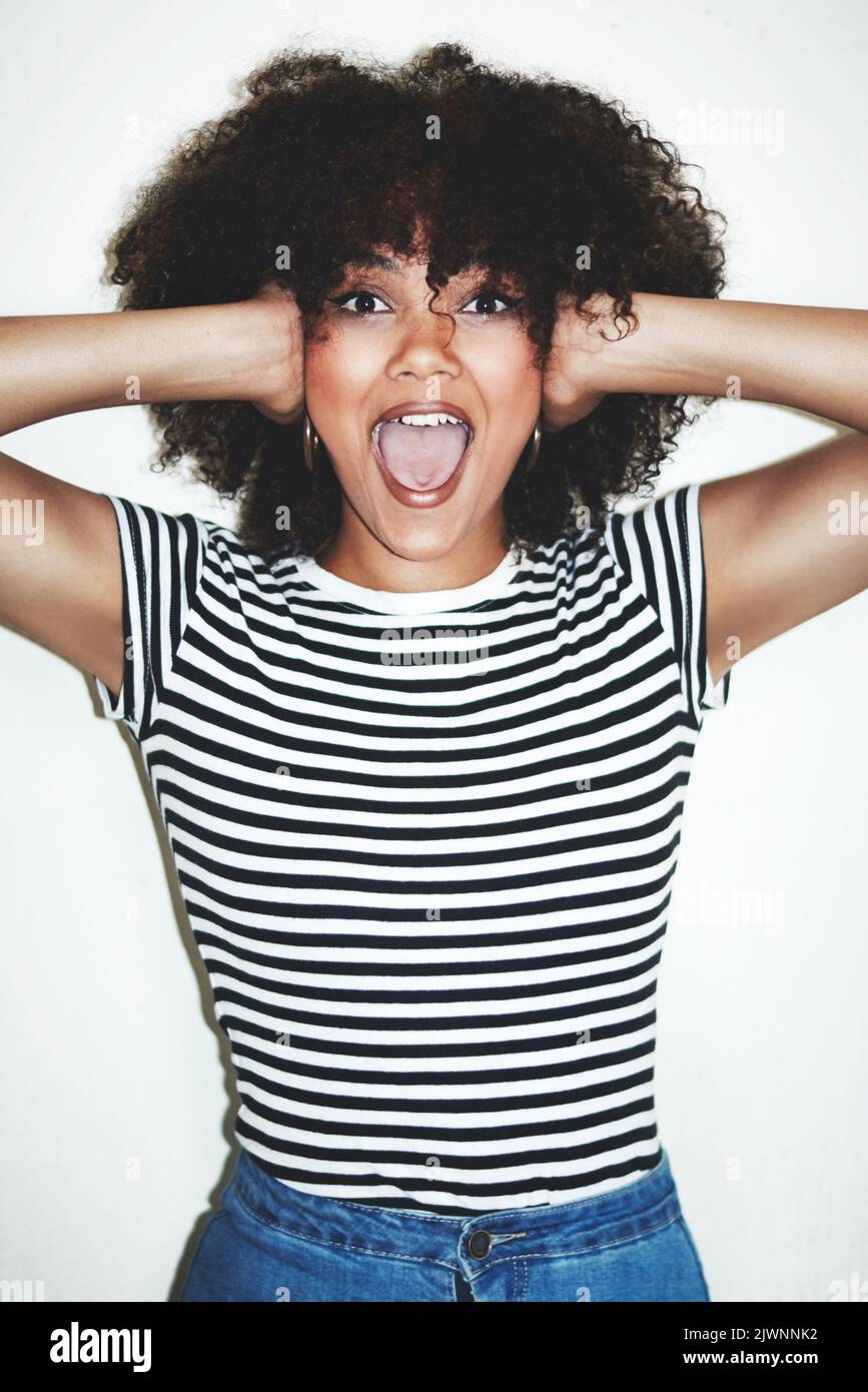C'est tellement fou. Photo en studio d'une jeune femme excitée posant sur un fond gris. Banque D'Images