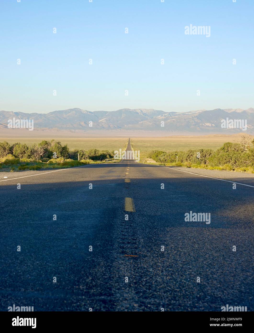 autoroute sans fin dans le désert menant aux montagnes Banque D'Images