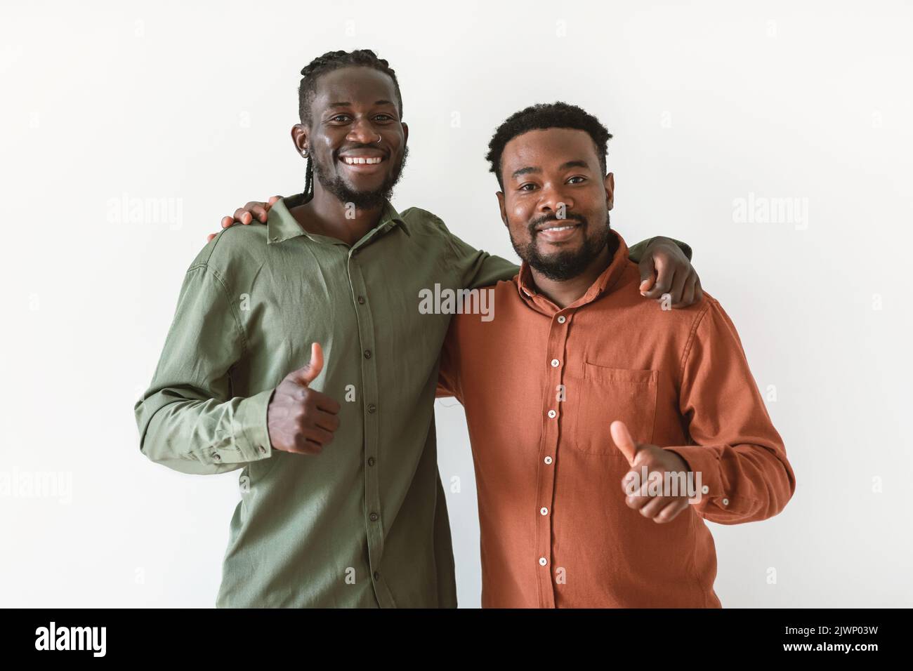 Deux hommes noirs qui se lancent sur des trombes s'embrassant sur fond blanc Banque D'Images