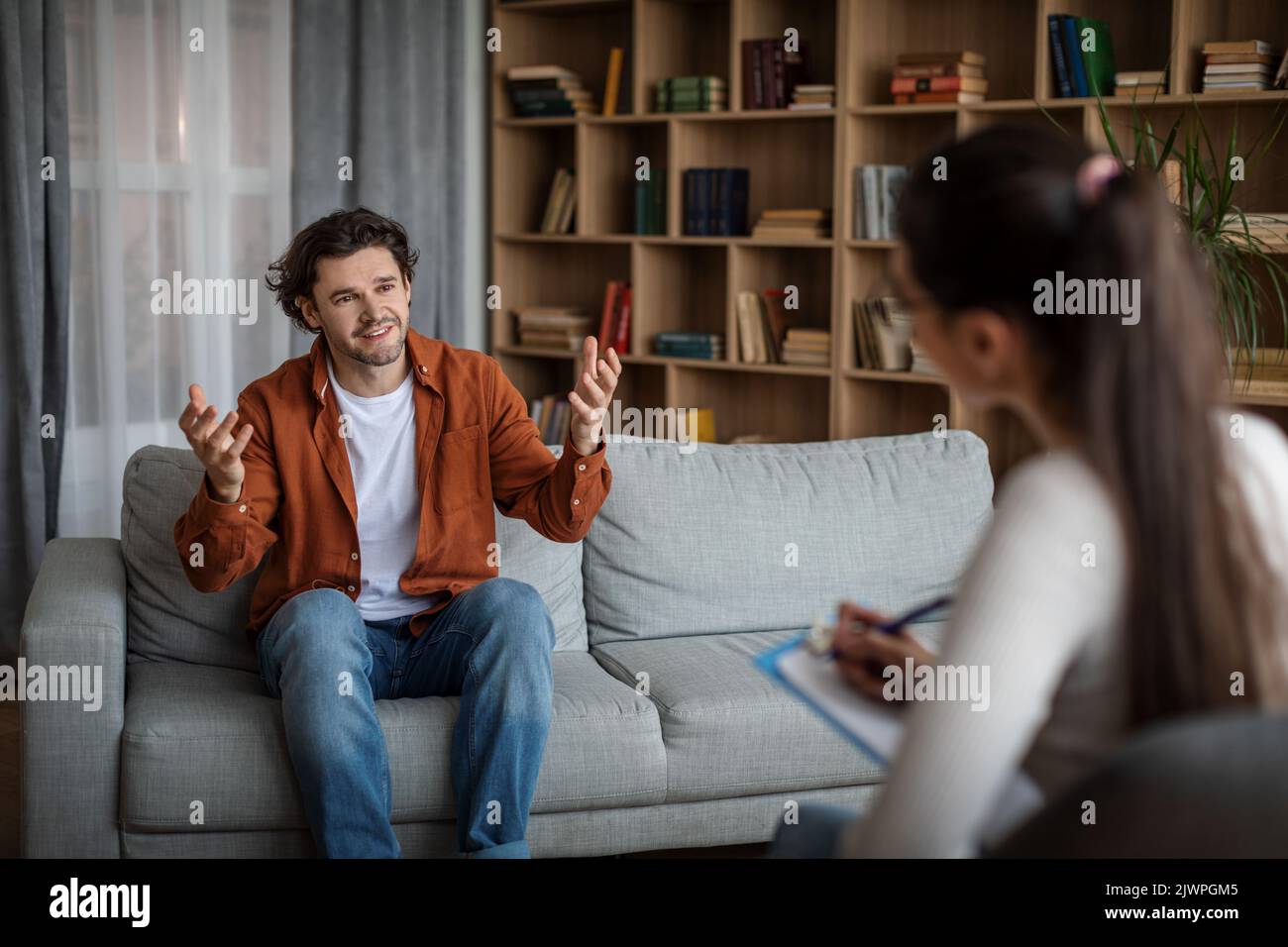 Sourire émotionnel jeune homme caucasien patient parle avec docteur psychologue dans le bureau Banque D'Images