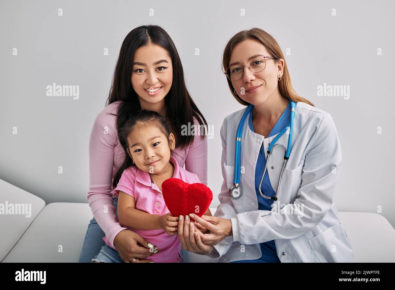 Pédiatrie. Une femme asiatique heureuse avec une fille en bonne santé assise avec son pédiatre après consultation du médecin en clinique médicale Banque D'Images