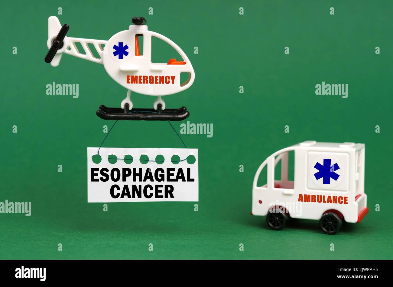 Concept médical. Sur une surface verte, une voiture d'ambulance et un hélicoptère avec un panneau - cancer oesophagien Banque D'Images