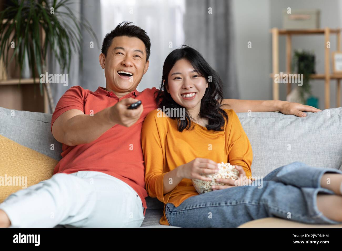 Une famille chinoise détendue regardant la télévision à la maison Banque D'Images