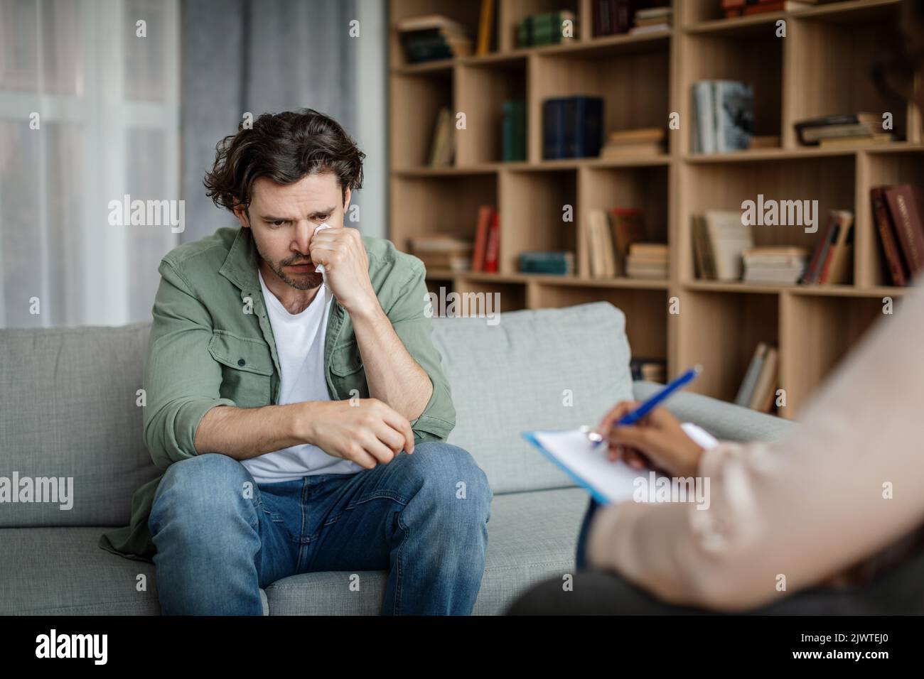 Un client millennal européen désapparié pleure lors d'une réunion avec une psychologue noire au bureau Banque D'Images