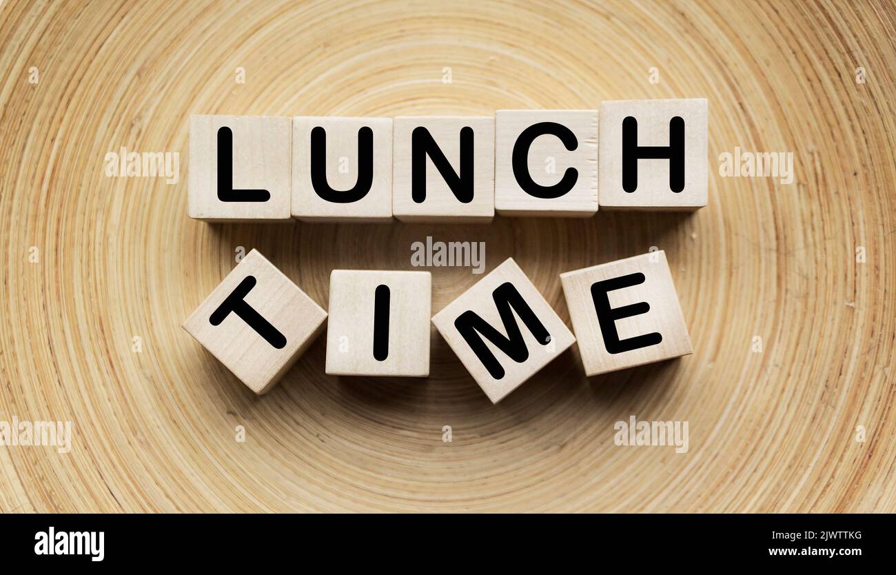 Blocs en bois avec le texte HEURE DU DÉJEUNER sur une plaque en bois Banque D'Images