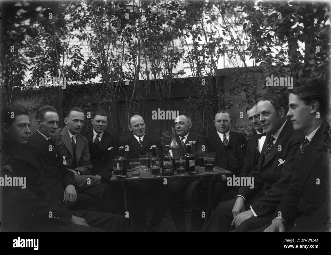 Des hommes se sont rassemblés autour d'une « table de grogg ». Män samlade kring ett 'groggbord'. Banque D'Images