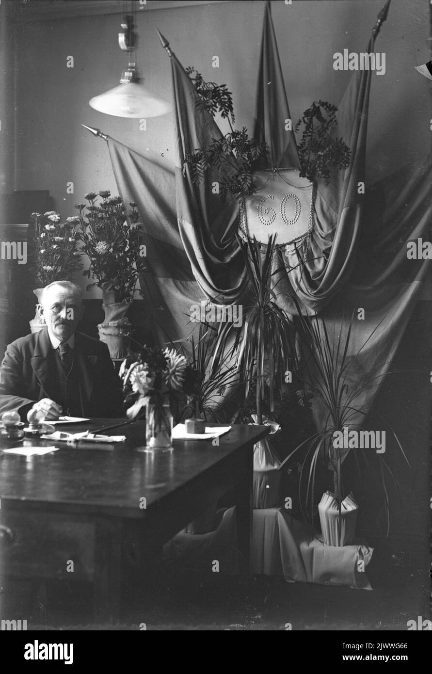 Anniversaire, 60th. Homme avec fleurs et drapeaux. Födelsedag, 60-årsfirande. Homme med fommor och fanor. Banque D'Images