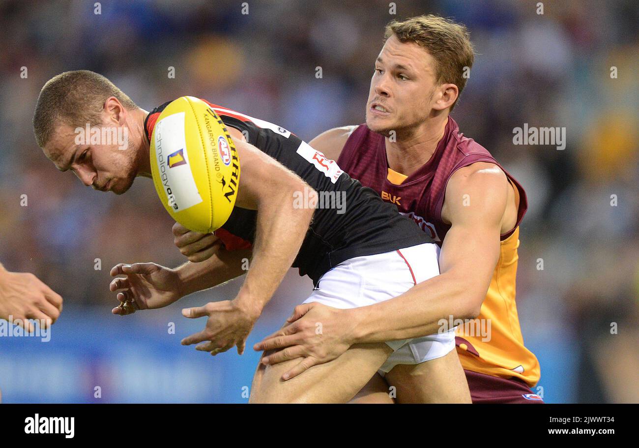 Le joueur des bombardiers David Zaharakis (à gauche) est attaqué par le joueur des Lions Jack Redden lors du match AFL de la série 8 entre les Lions de Brisbane et les bombardiers Essendon au Gabba à Brisbane, samedi, 10 mai 2014. (AAP image/Dave Hunt) Banque D'Images