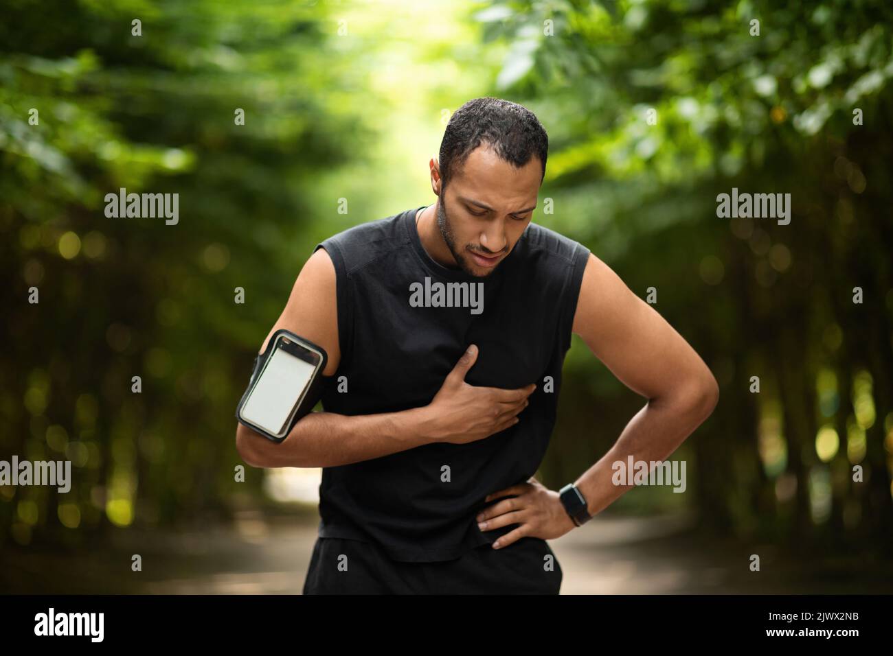 Homme noir musclé avec douleur cardiaque, entraînement à l'extérieur Banque D'Images
