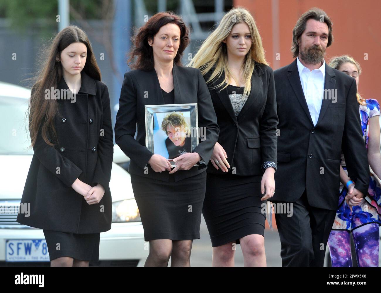 Karin Keays (photo de la pièce), veuve des maîtres apprentis, le chanteur Jim Keays, marche avec ses filles Bonnie et Holly et le fils de Jim de son premier mariage, James Keays, alors qu'ils mènent sa procession funéraire à Ormond Hall à Melbourne, vendredi, 20 juin 2014. Le chanteur principal de l'emblématique groupe des années soixante qui a écrit la chanson « parce que je t'aime » est mort sur 13 juin cette année. (Image AAP/Julian Smith) Banque D'Images
