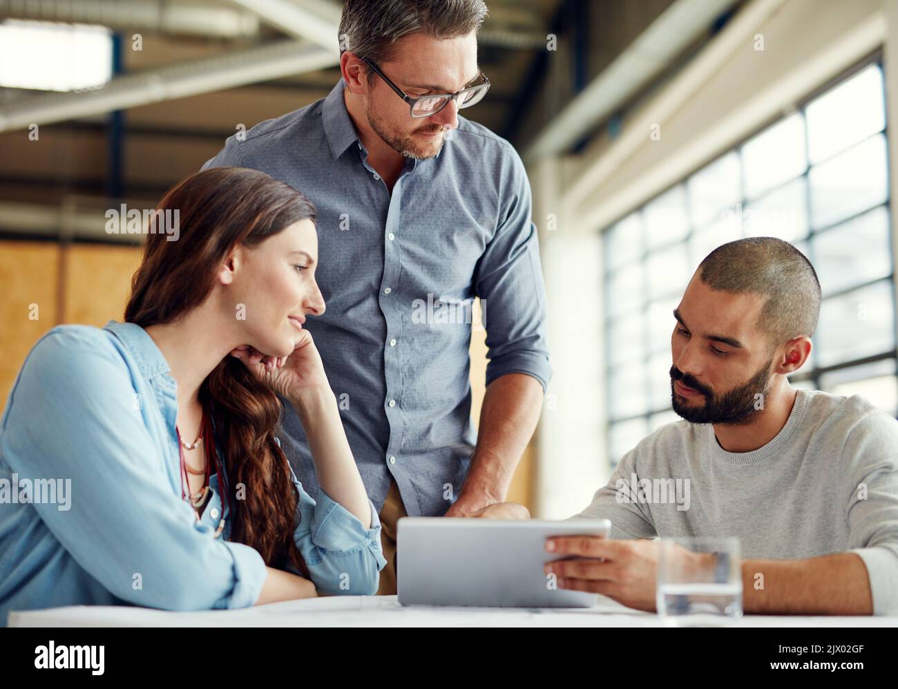 Faire des tombeaux de succès aujourd'hui. Un groupe de collègues ayant une réunion dans un bureau ouvert plan. Banque D'Images