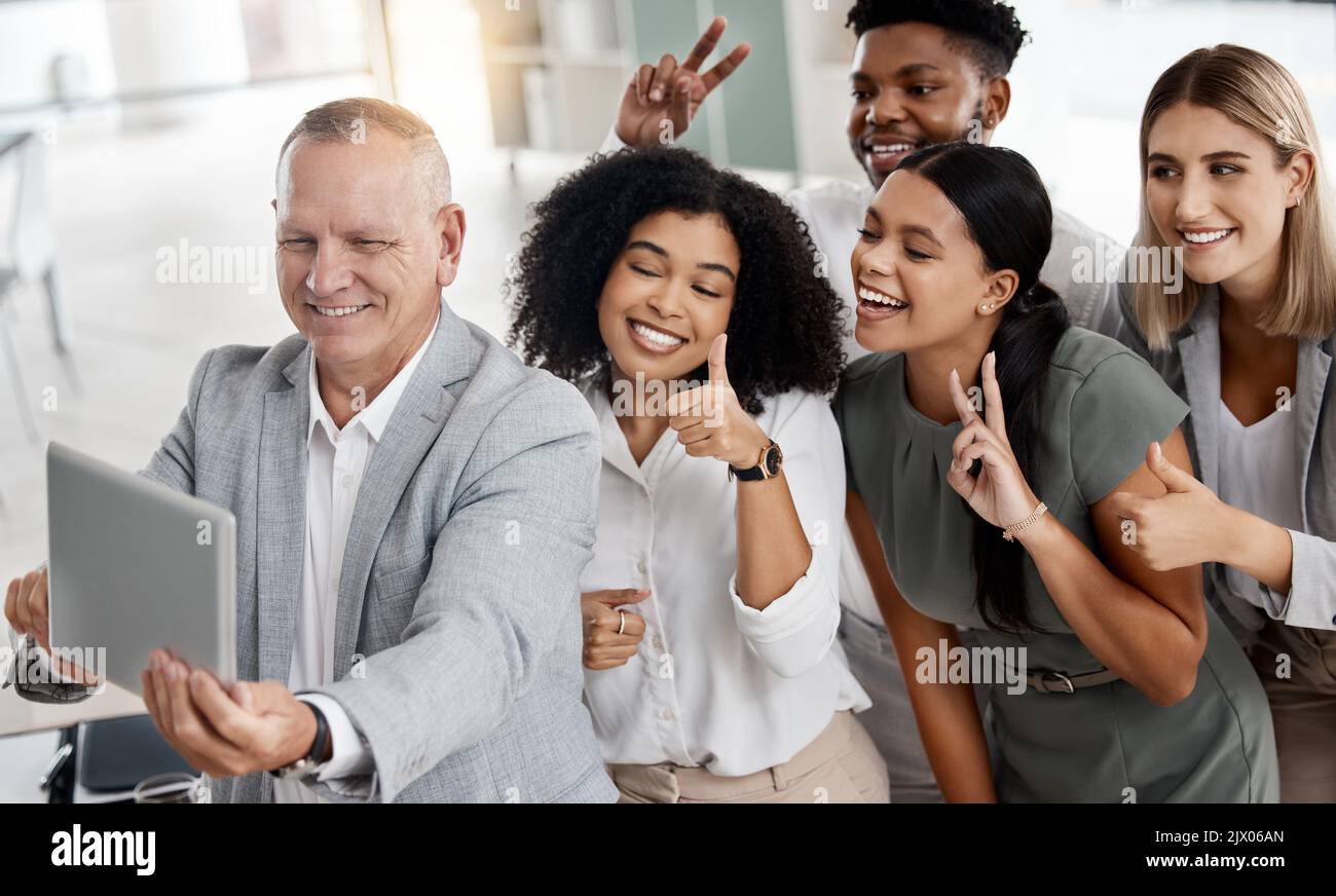 Équipe de démarrage, heureux et prendre un selfie sur une tablette avec un sourire au bureau. La diversité, le succès et un chef de la direction enthousiaste s'amusant avec les panneaux et Banque D'Images