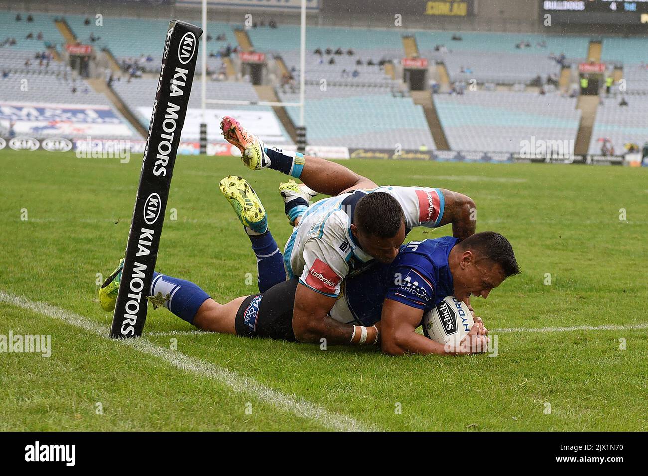 Sam Perrett des Bulldogs est attaqué par Josh Hoffman des Titans alors qu'il marque un essai lors de la ronde 8 NRL match entre les Bulldogs de Canterbury-Bankstown et les Titans de la Gold Coast au stade ANZ à Sydney, samedi, 23 avril 2016. (Image AAP/Dan Himbrechts) Banque D'Images