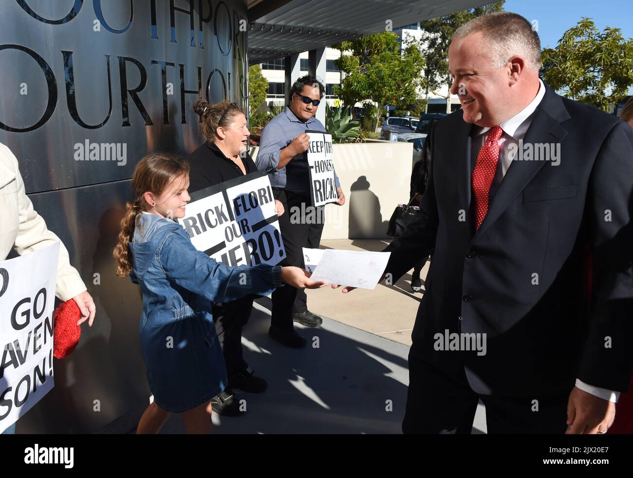 Le sergent Rick Flori, officier de police du Queensland, reçoit un message sympathique d'un jeune partisan alors qu'il arrive au tribunal des magistrats de la Côte d'Or, vendredi, 20 mai 2016. M. Flori a été inculpé d'inconduite dans un bureau public après avoir perdu des images du chef Noa Begic, 22 ans, frappé par la police alors qu'il avait menotté à la main après une arrestation à Surfers Paradise en janvier 2012. (Image AAP/Dan marqué) Banque D'Images