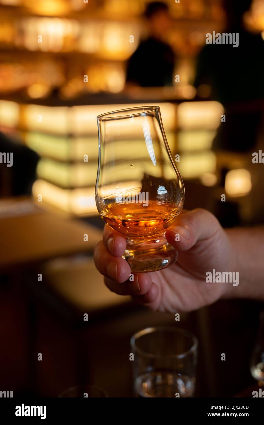 Dégustation de whisky single malt scotch au bar écossais d'Édimbourg, Royaume-Uni, main avec un verre de whisky Banque D'Images