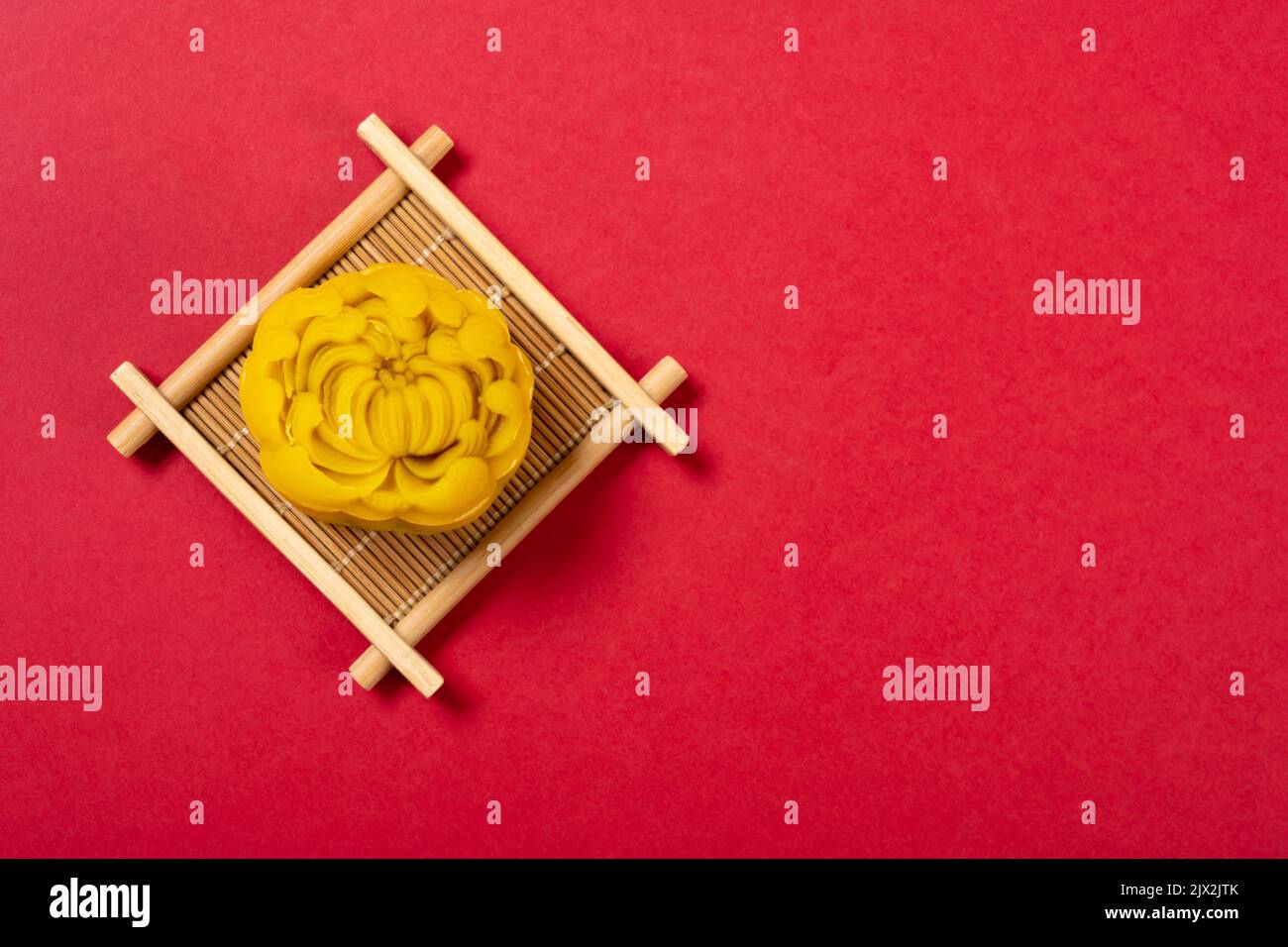 gâteau de lune en forme de fleur tendance sur fond rouge avec espace de copie Banque D'Images