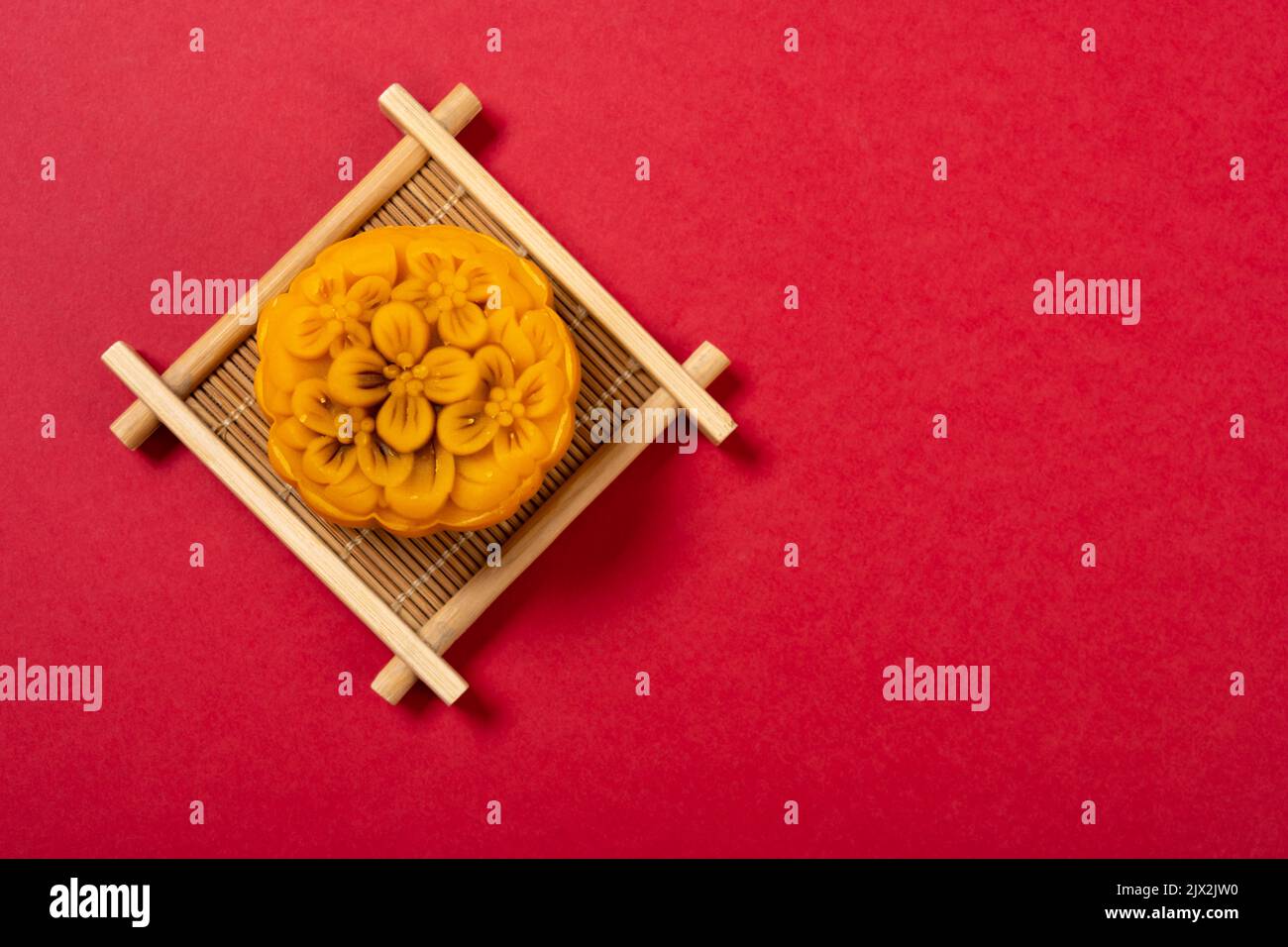 gâteau de lune en forme de fleur tendance sur fond rouge avec espace de copie Banque D'Images