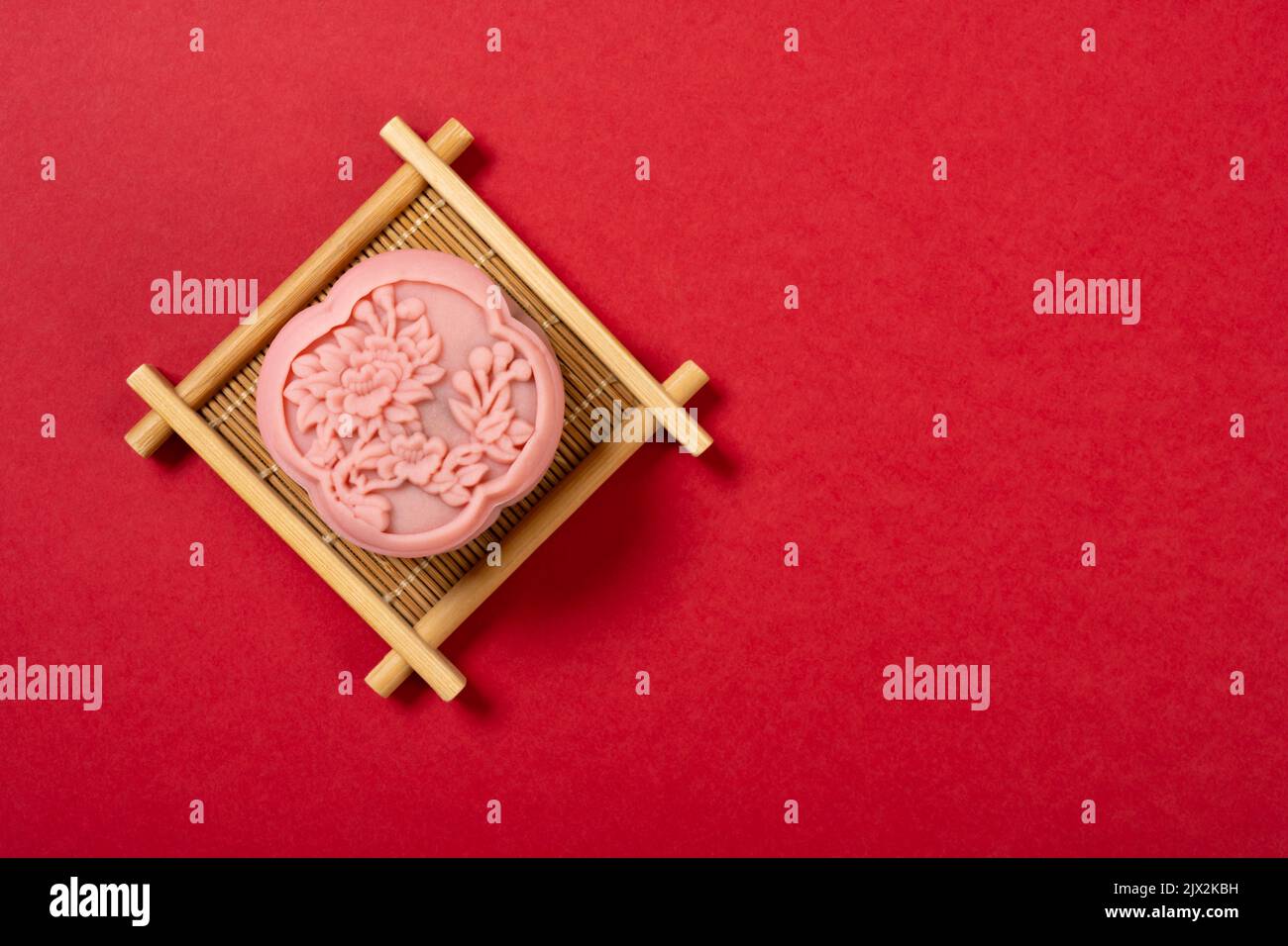 gâteau de lune en forme de fleur tendance sur fond rouge avec espace de copie Banque D'Images
