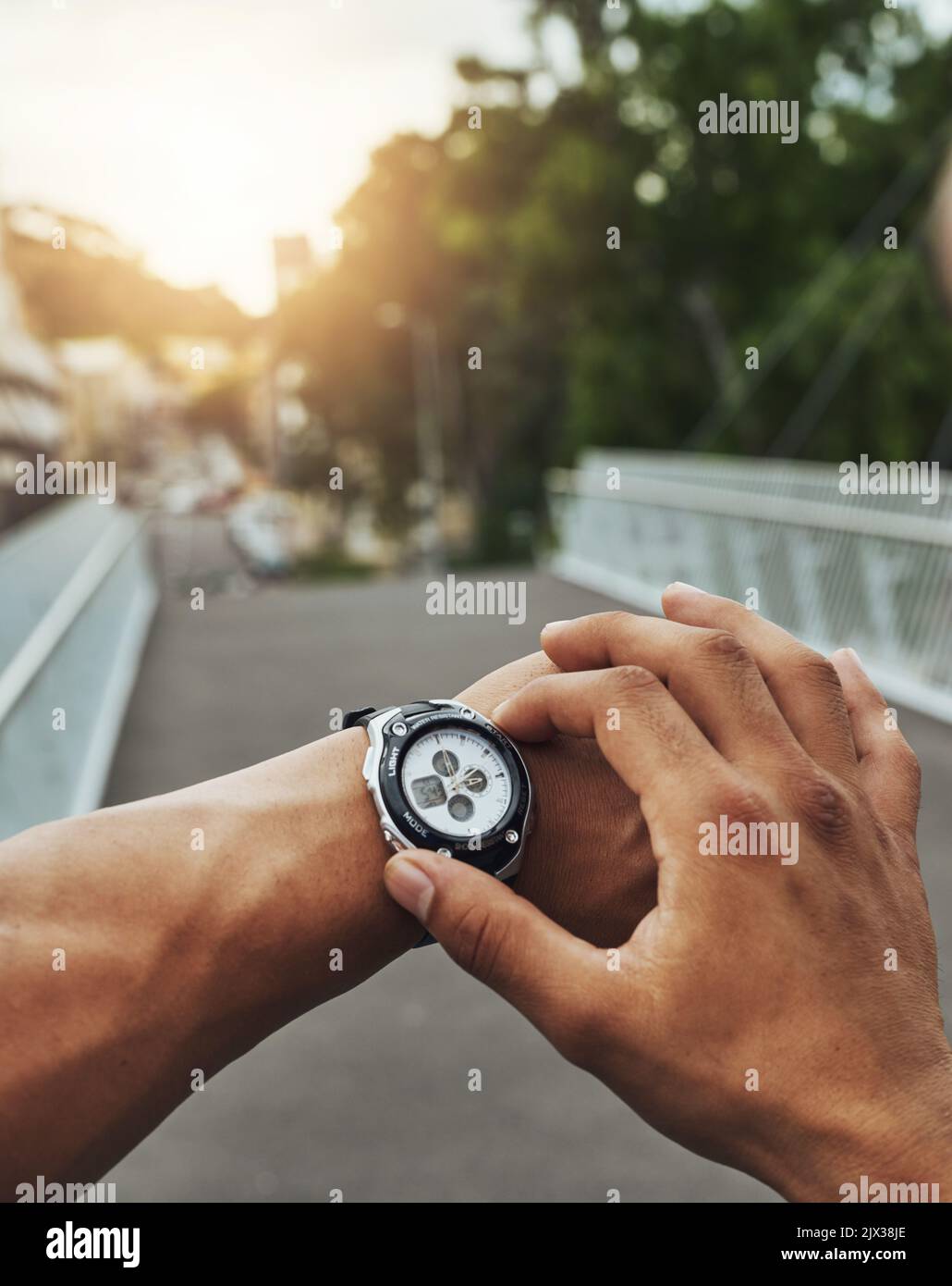 Progresser sur la voie de la remise en forme. Un coureur qui vérifie sa montre de sport pendant son entraînement. Banque D'Images
