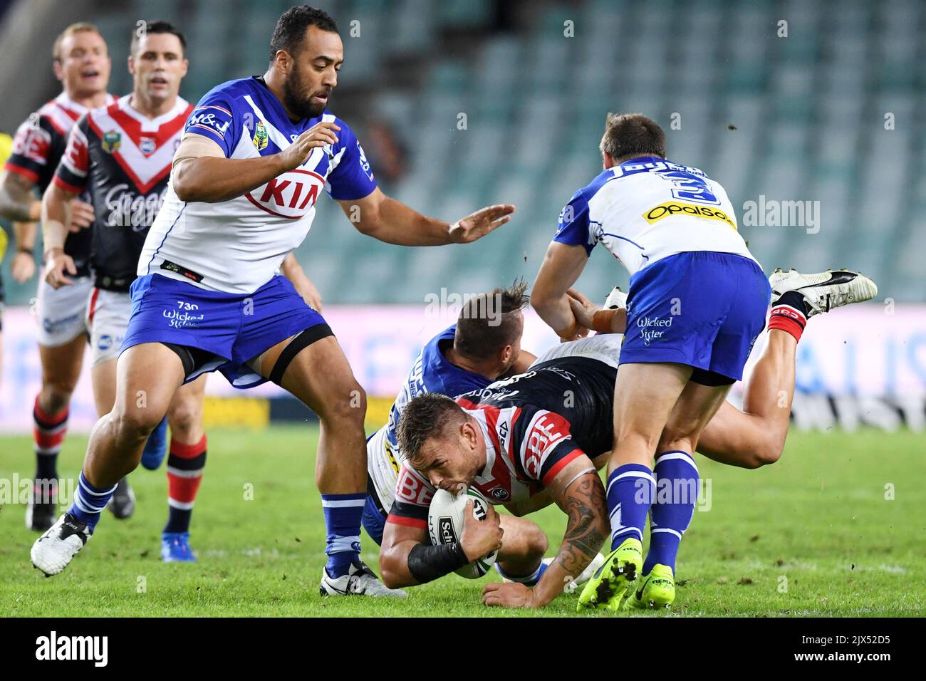 Jared Waerea-Hargreaves (au centre) des Roosters est attaqué par Josh Reynolds, Josh Morris (à droite) et Sam Kasiano (à gauche) des Bulldogs lors du match de la manche 2 entre les Roosters de Sydney et les Bulldogs de Canterbury-Bankstown, au stade Allianz de Sydney, jeudi, 9 mars 2017. (AAP image/Paul Miller) Banque D'Images