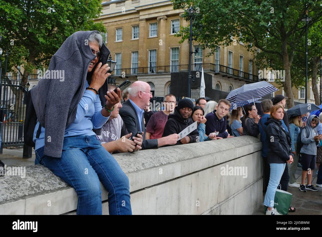 Londres, Royaume-Uni, 6th septembre 2022. Une femme s'assoit sur un mur en face de Downing Street avec un polaire sur sa tête alors qu'elle commence à pleurer avant l'arrivée tardive de Liz Truss au numéro 10. Après le vote des membres du Parti conservateur, Liz Truss s'est rendu à Balmoral pour rencontrer la Reine, devenant ainsi le nouveau Premier ministre du Royaume-Uni. Crédit : onzième heure de photographie/Alamy Live News Banque D'Images