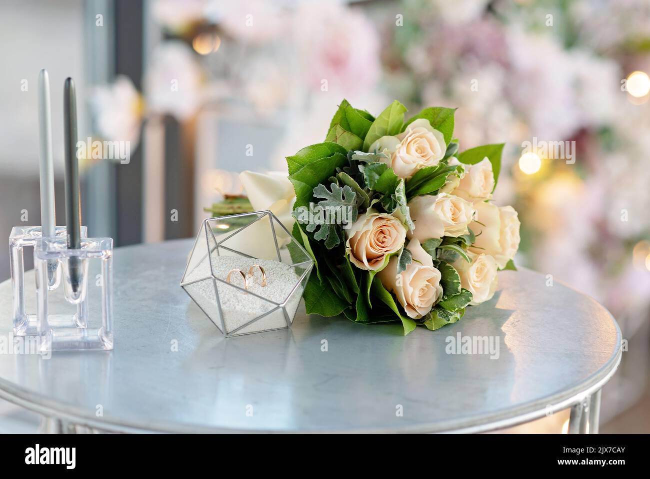 Une paire de magnifiques anneaux de mariage dans un support en verre moderne et un délicat bouquet de roses de mariée. Mariage, cérémonie. Mise au point sélective douce. Banque D'Images Une paire de magnifiques anneaux de mariage dans un support en verre moderne et un délicat bouquet de roses de mariée. Mariage, cérémonie. Mise au point sélective douce. Banque D'Images