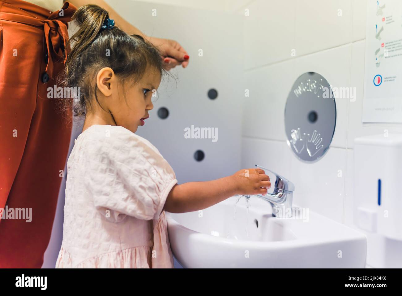Une jeune fille se lavant les mains avec du savon après le jeu à l'école maternelle. Concept de l'apprentissage précoce de l'hygiène saine pour le bien-être des enfants. Photo de haute qualité Banque D'Images