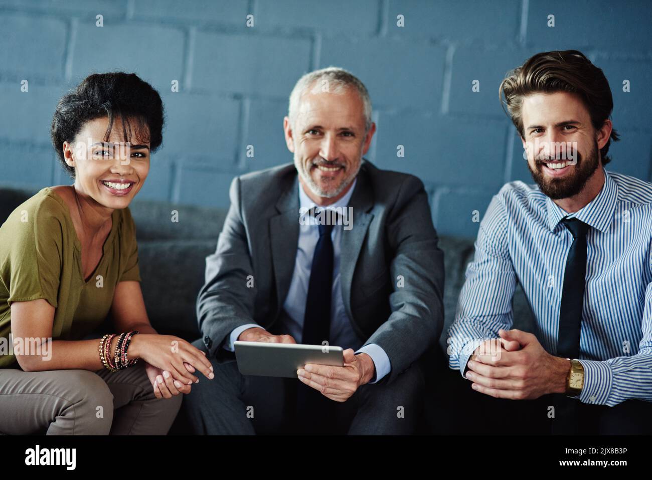 Nous sommes fiers de notre équipe simpatico. Portrait d'un groupe de collègues travaillant avec une tablette numérique. Banque D'Images