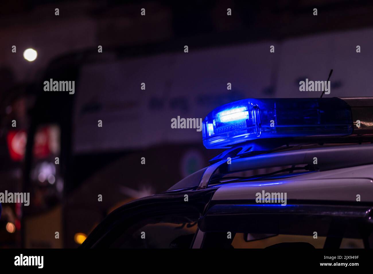 Lumière d'urgence de la police patrouilant la voiture dans la rue la nuit Banque D'Images