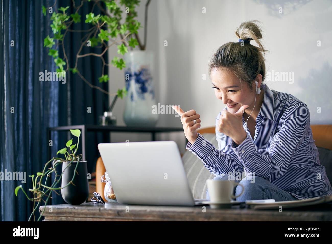 femme asiatique professionnelle mûre travaillant à la maison chat vidéo à l'aide d'un ordinateur portable heureux et souriant Banque D'Images