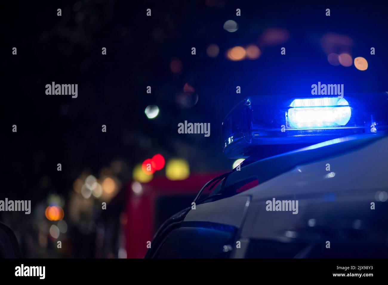 Lumière d'urgence de la police patrouilant la voiture dans la rue la nuit Banque D'Images