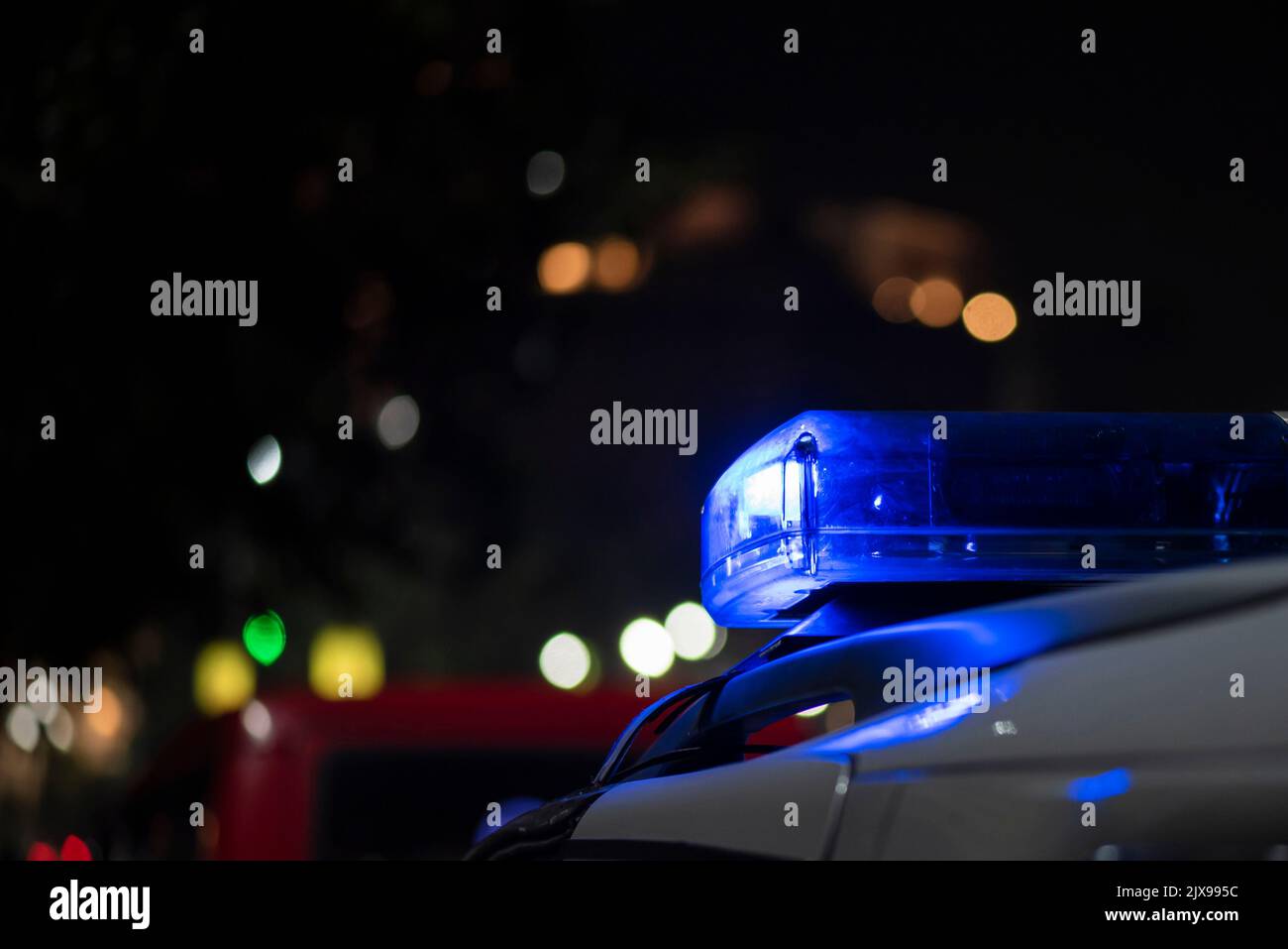 Lumière d'urgence de la police patrouilant la voiture dans la rue la nuit Banque D'Images