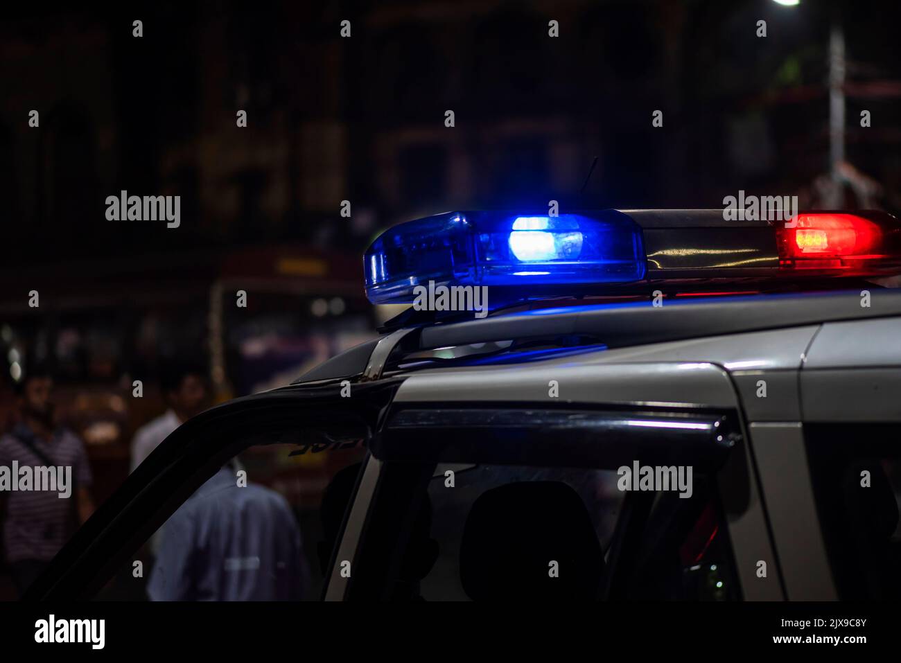 Lumière d'urgence de la police patrouilant la voiture dans la rue la nuit Banque D'Images