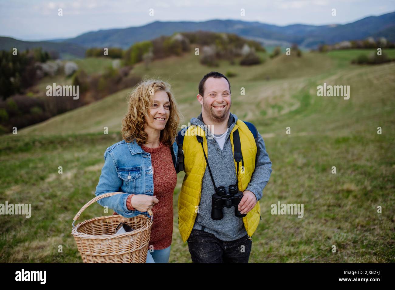 Portrait du jeune homme heureux avec le syndrome de Down avec sa mère randonnée ensemble dans la nature. Banque D'Images
