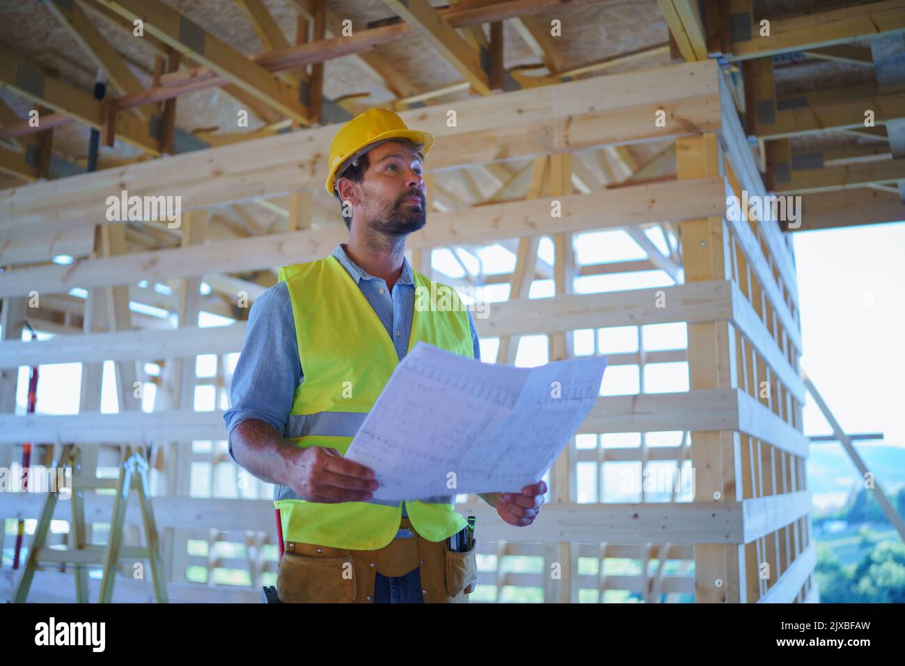 Ingénieur de construction ou architecte avec des plans de visite et de damier site de construction écologique de la maison de cadre en bois Banque D'Images