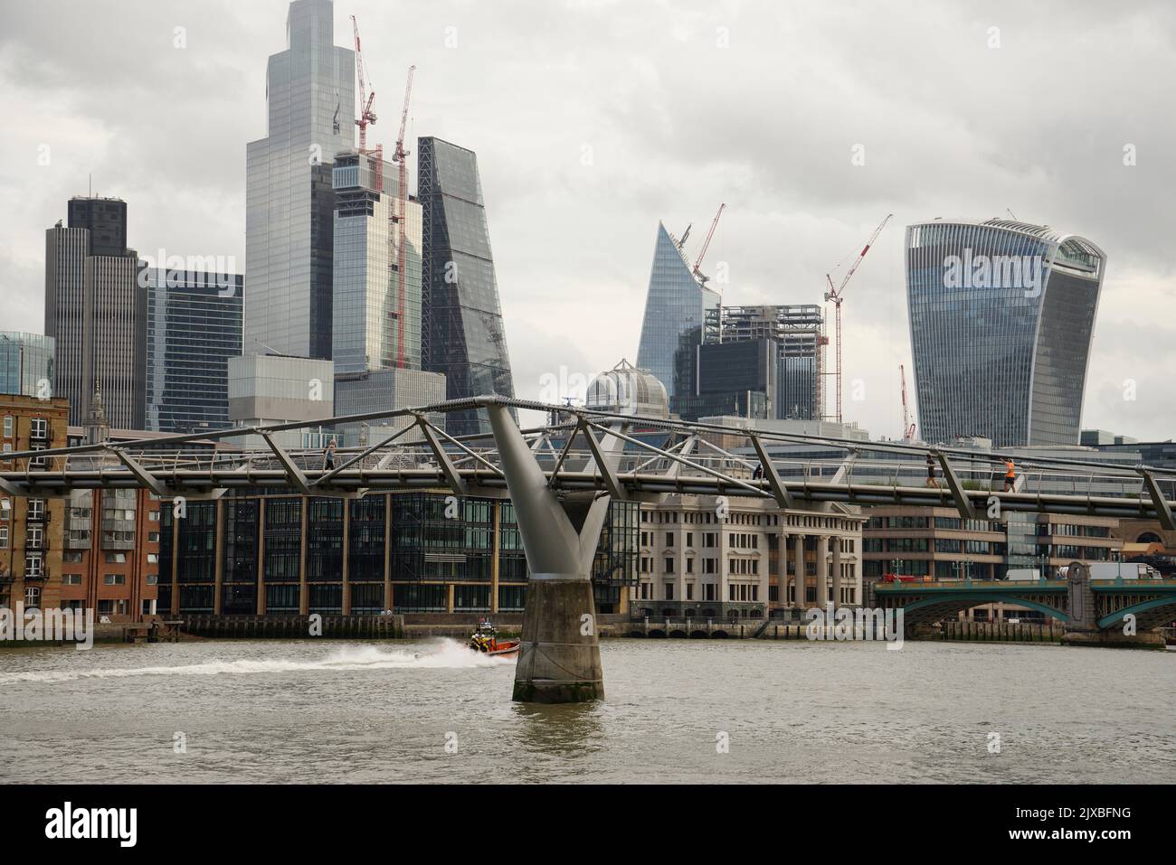 La ville de Londres et le pont du Millennium Walkway en premier plan. Bateau RNLI sur le chemin d'un appel. Banque D'Images