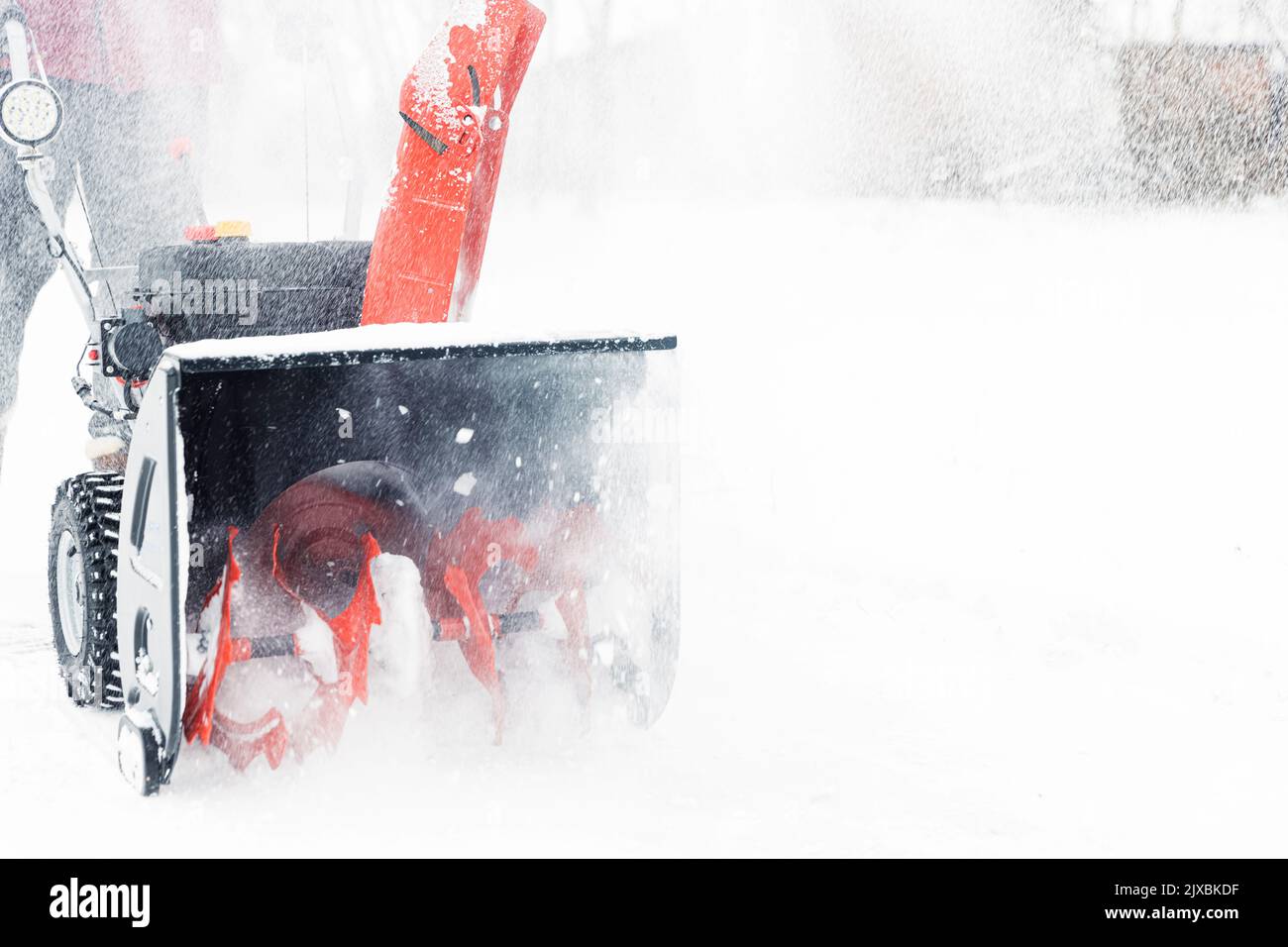 Détail de la souffleuse à neige rouge portable alimentée par l'essence en action. Homme à l'extérieur utilisant une souffleuse à neige après une tempête de neige, chute de neige pour le défrichement, déneigement. Déneigement, assistant de fraise Banque D'Images
